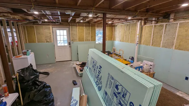 A basement is being remodeled and there is a stack of styrofoam in the middle of the room.