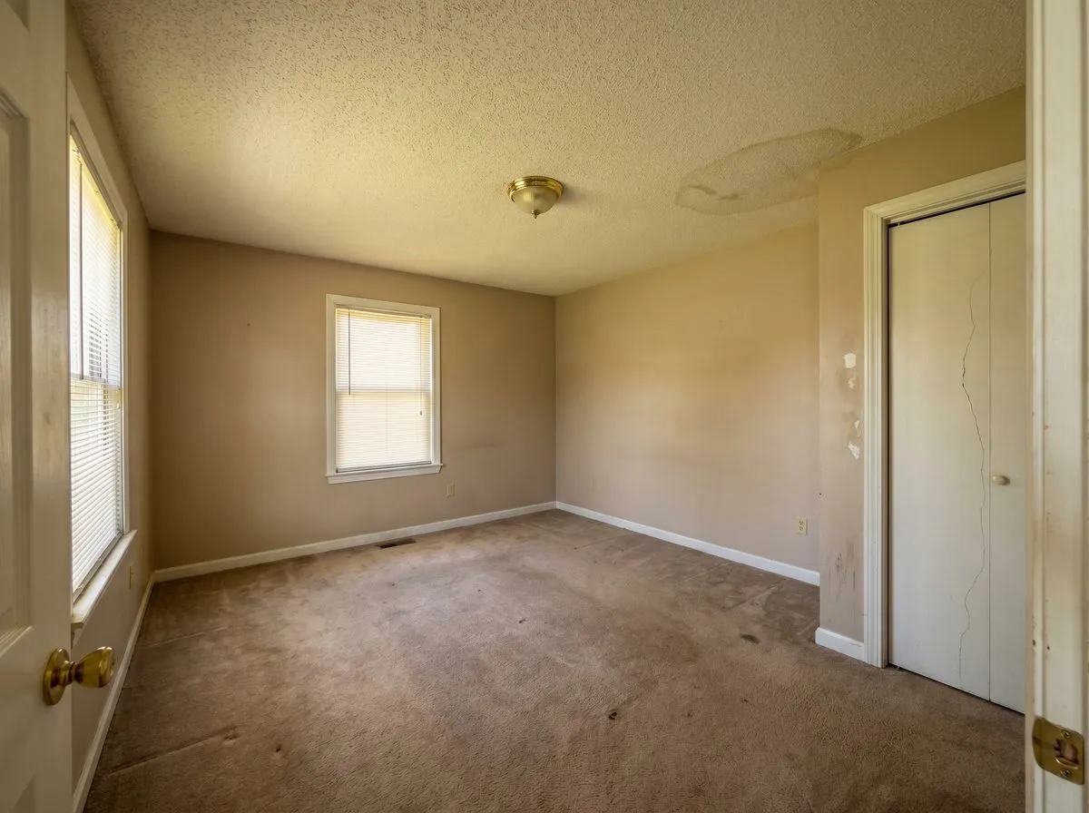 Dated master bedroom with beige walls and popcorn ceiling — before professional repaint