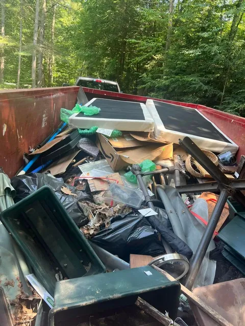 Dumpster loaded with household debris and furniture