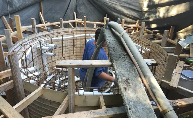 A man is standing in the middle of a building under construction.