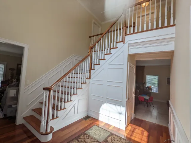 Beautiful wainscoting and decorative trimwork in a foyer, painted white to make the finish carpentry work pop