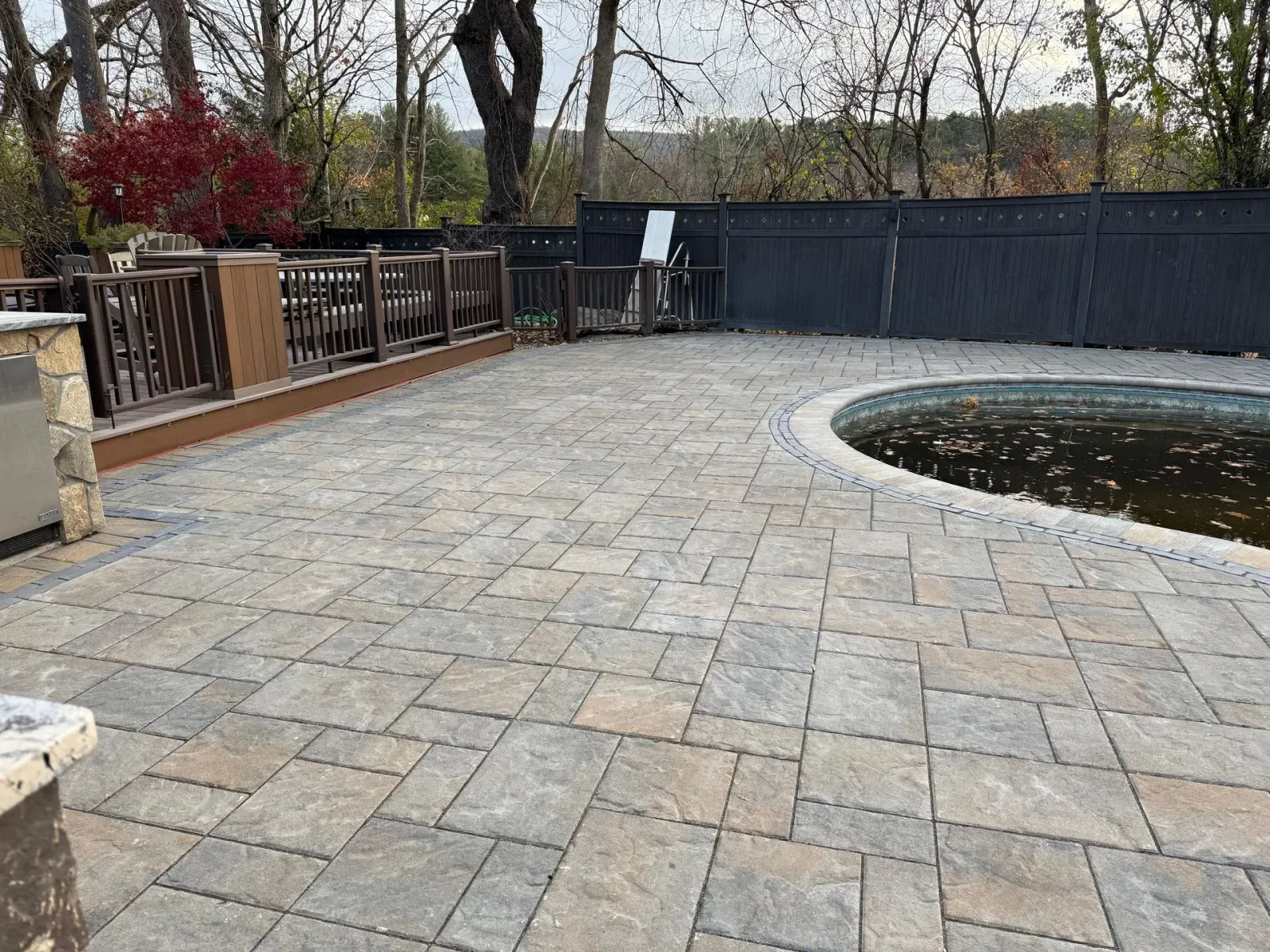 A patio with a swimming pool in the middle of it.