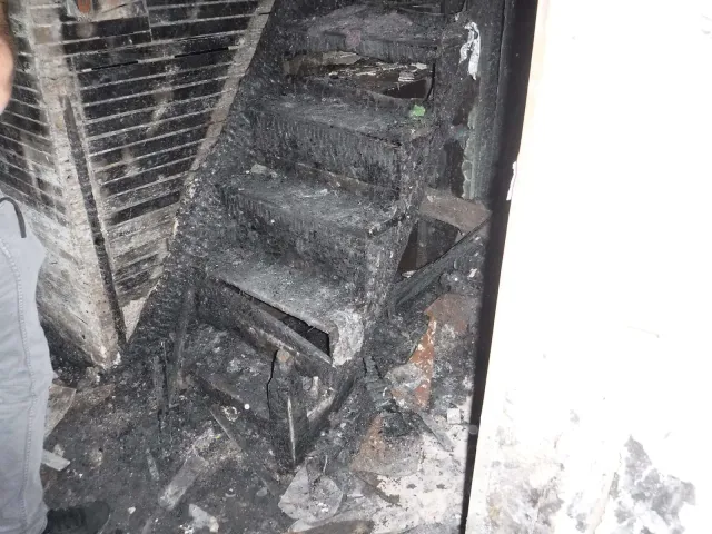 Charred basement staircase after a house fire requiring full IICRC S700 fire and smoke restoration