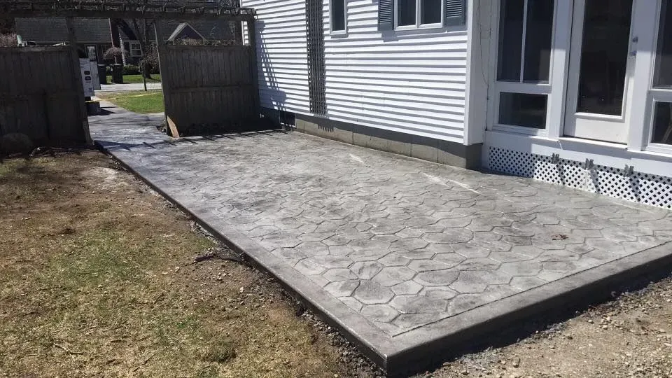 A concrete patio is being built in front of a house.