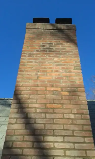 Rebuilt brick chimney with a new concrete crown and cap