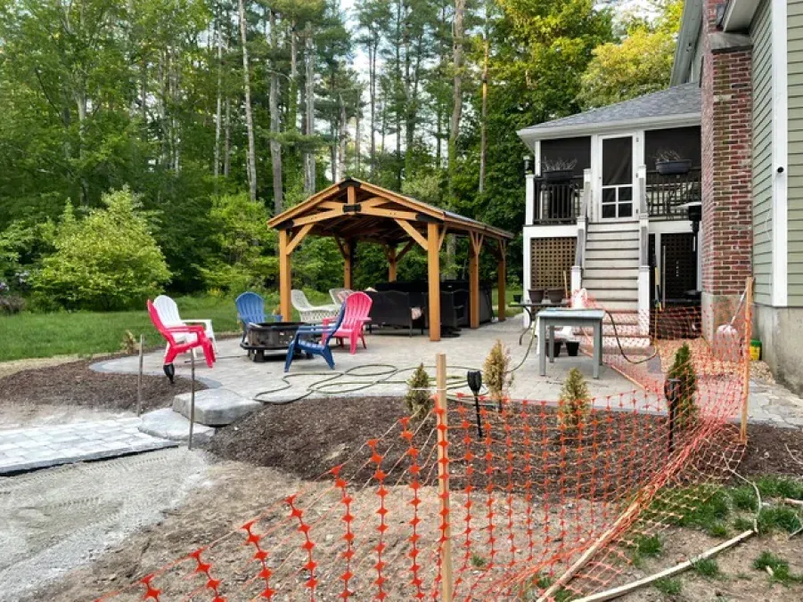 A house with a screened in porch and a gazebo in the backyard.