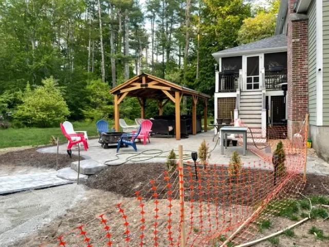 A house with a screened in porch and a gazebo in the backyard.