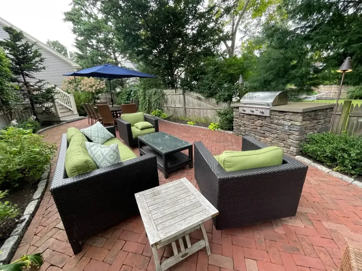 Brick patio with natural stone outdoor kitchen and custom masonry seating area in Marblehead, MA