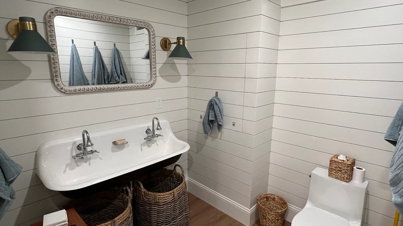 Shiplap bath with cast-iron trough sink and brass sconces