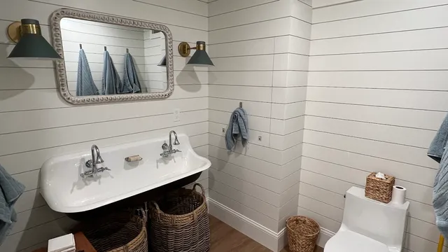 Shiplap bath with cast-iron trough sink and brass sconces