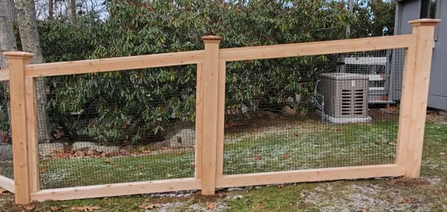 A wooden fence with a wire fence around it