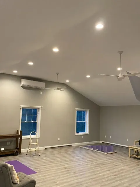 Partially finished gray room with recessed lights, ceiling fan, windows, and ladder on a new floor
