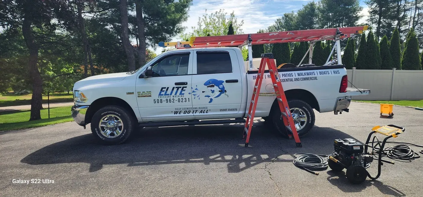 White pickup truck with ladder and equipment.