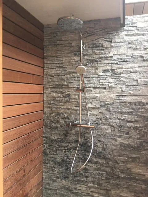 Outdoor shower fixture on stacked stone wall