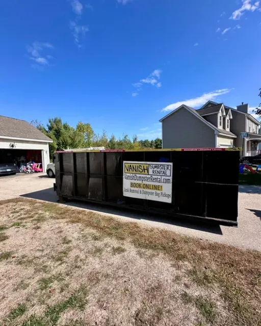 Vanish Dumpster Rental roll-off dumpster parked in a residential driveway