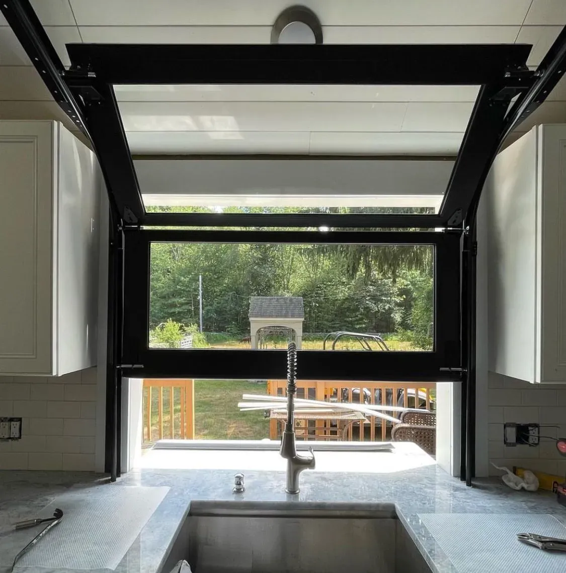 A kitchen with a sink and a window that is open