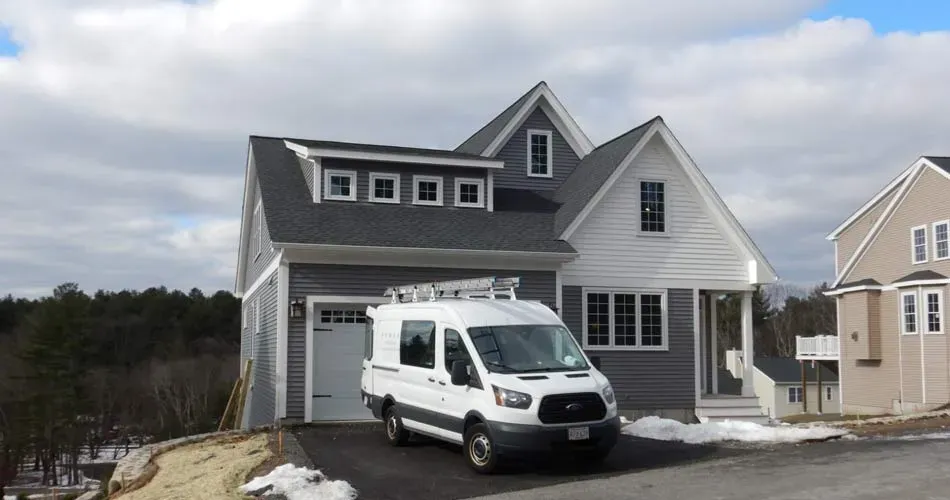 a contractor van parked in front of  a recently constructed house