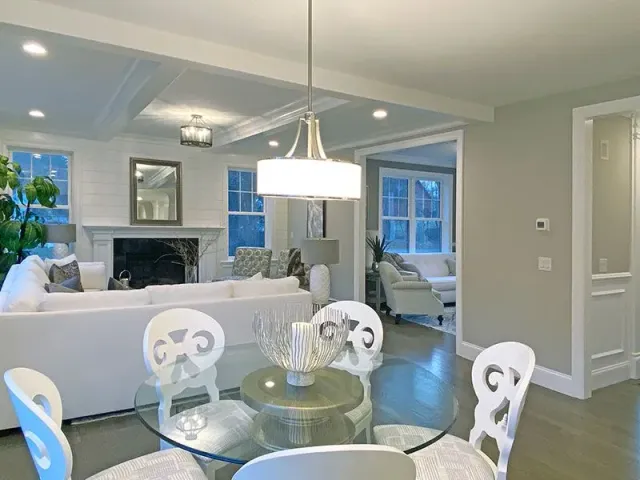 A living room with a glass dining table and chairs