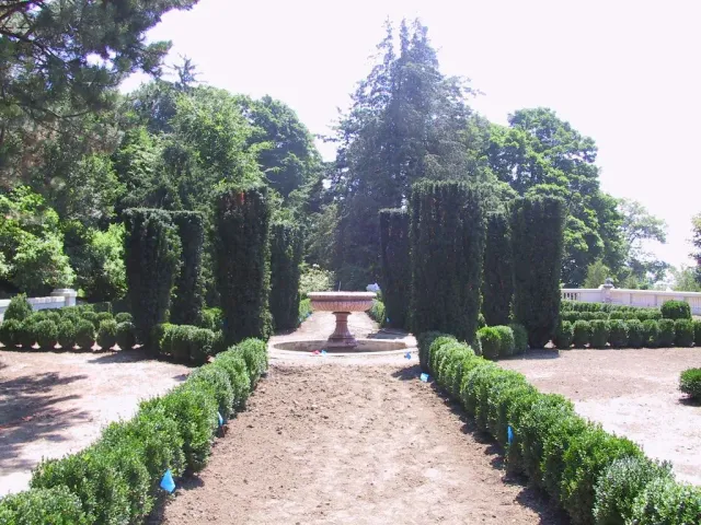 A lush green garden with a fountain in the middle