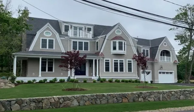 Large modern house  multiple gables, a front porch, and a garage