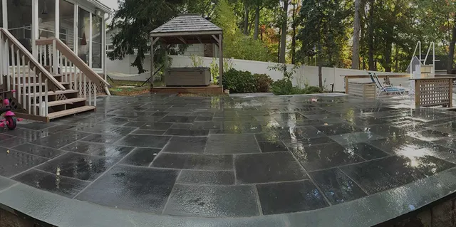 A large patio with a gazebo and stairs in the backyard.