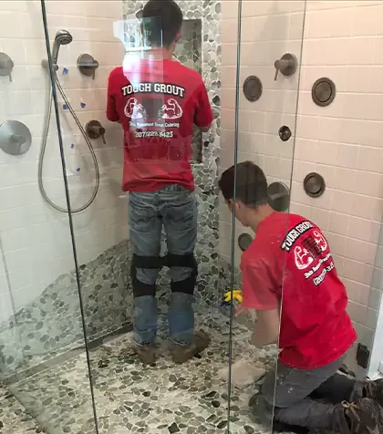 Two Tough Grout employees working in shower