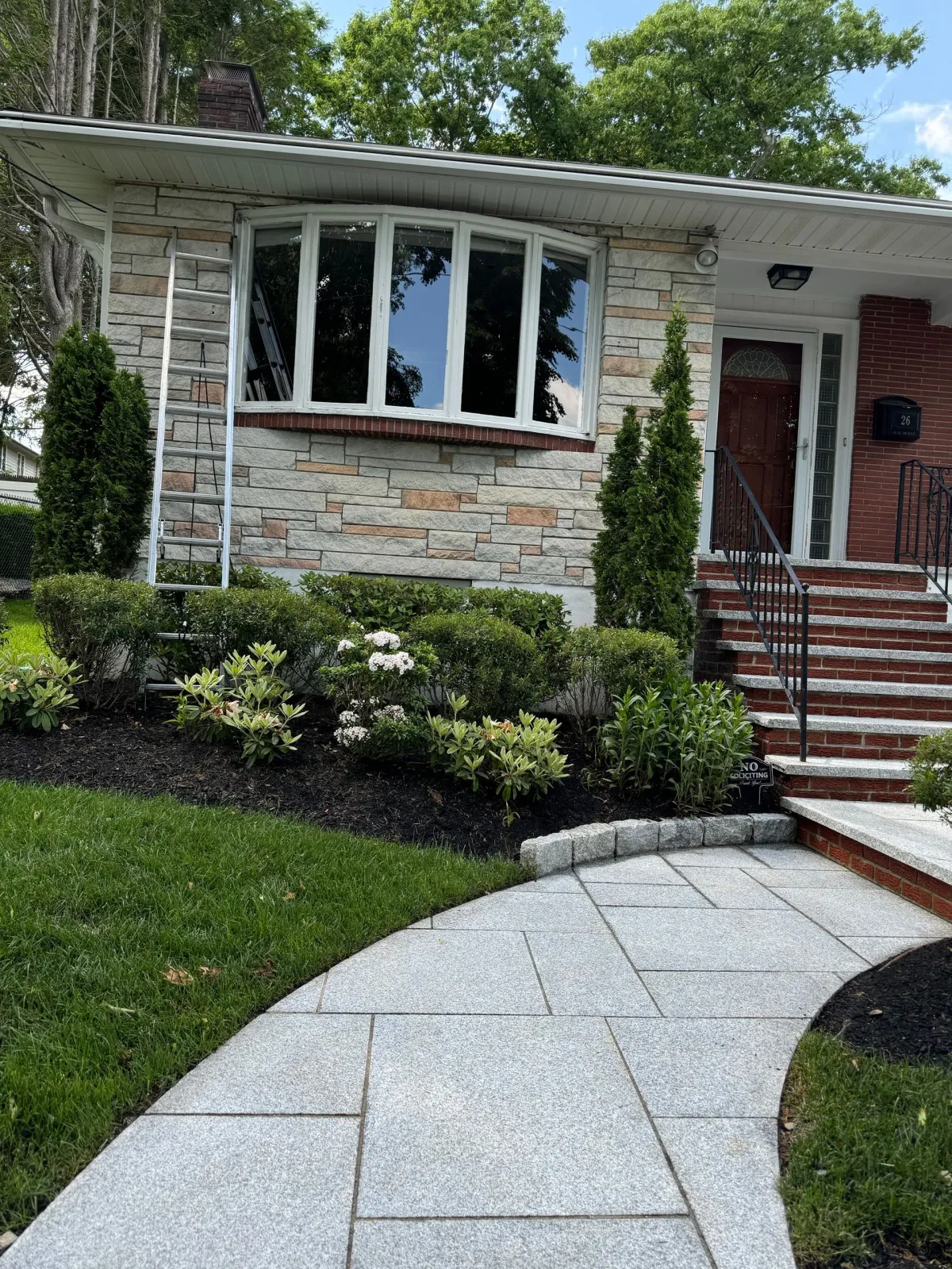 There is a walkway leading to the front of a house.