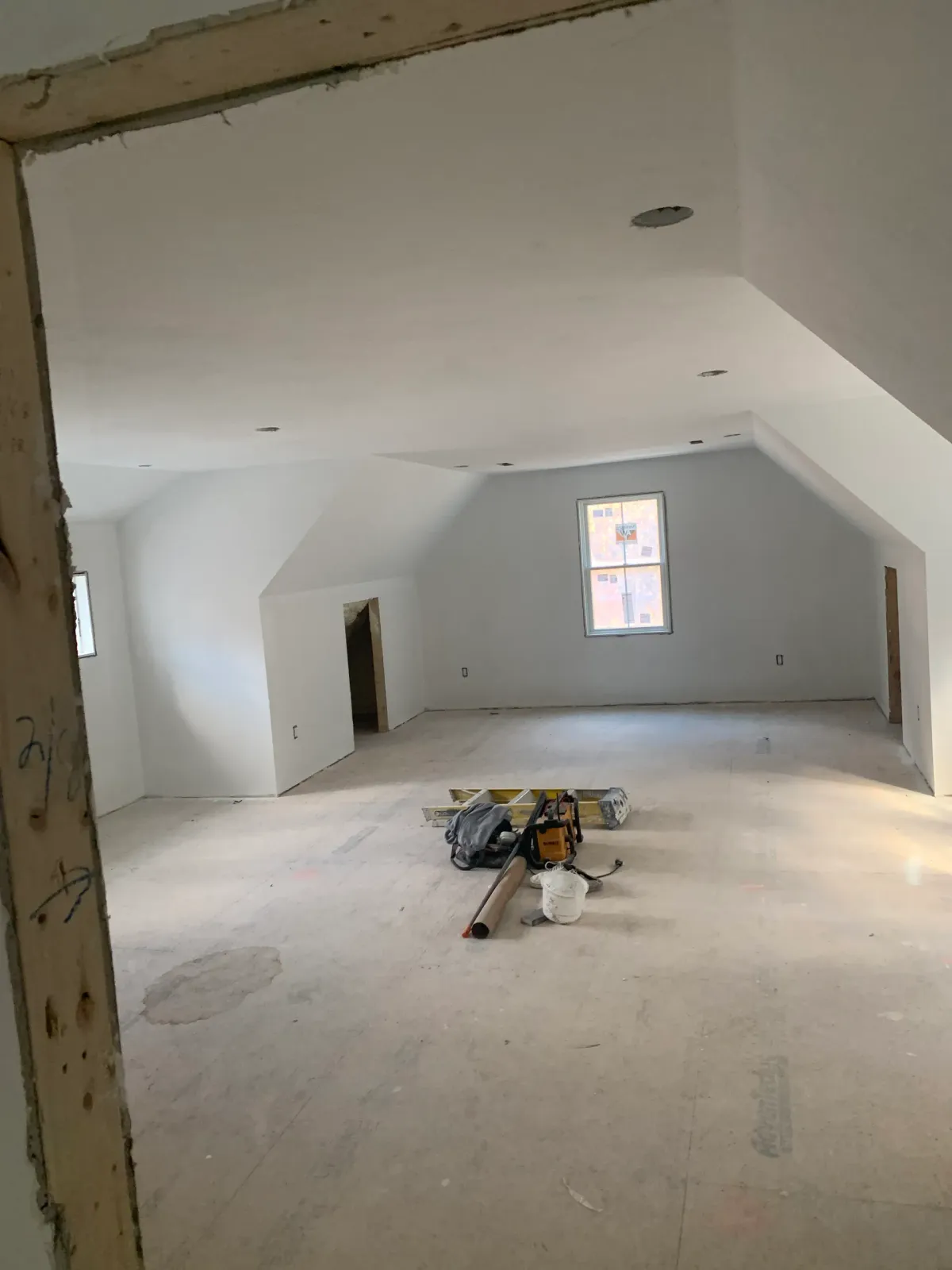 A large empty room with a window in the corner.
