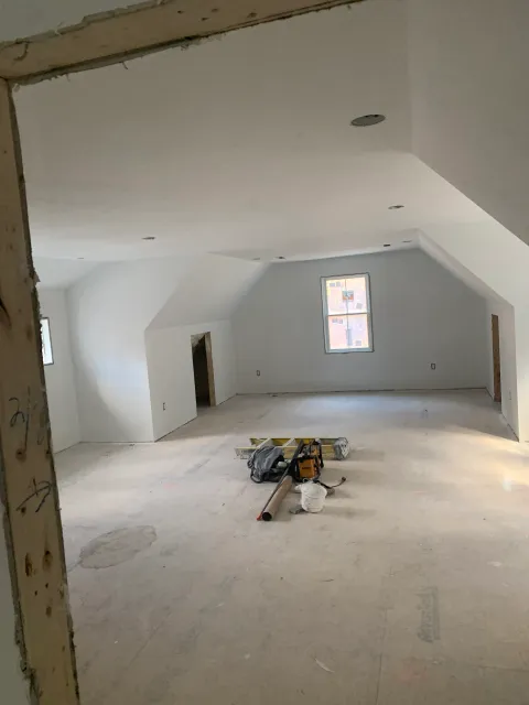 A large empty room with a window in the corner.
