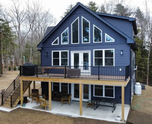 Custom deck construction and blue vinyl siding installation on a home in Goffstown, New Hampshire.