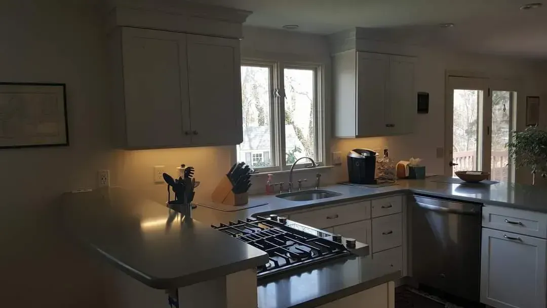 A kitchen with white cabinets and stainless steel appliances