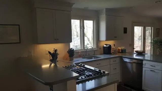 A kitchen with white cabinets and stainless steel appliances