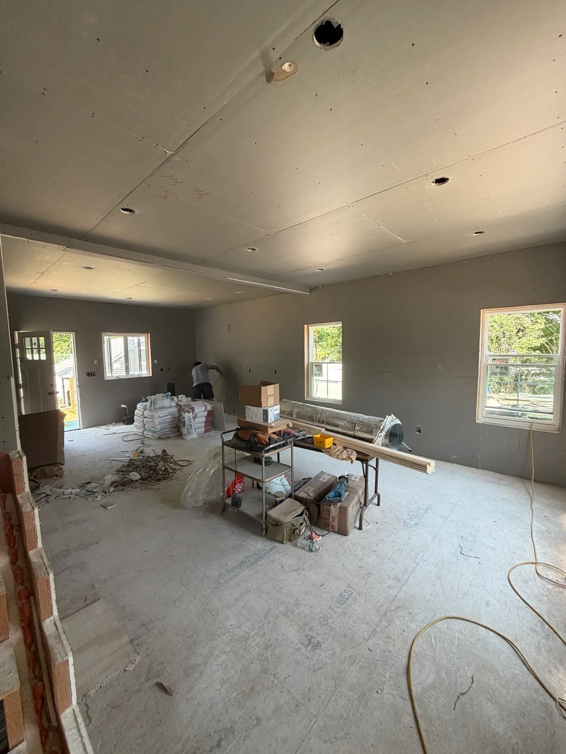 Open kitchen and living area during drywall and rough construction