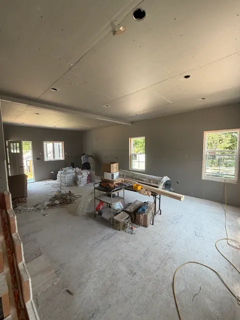 Open kitchen and living area during drywall and rough construction