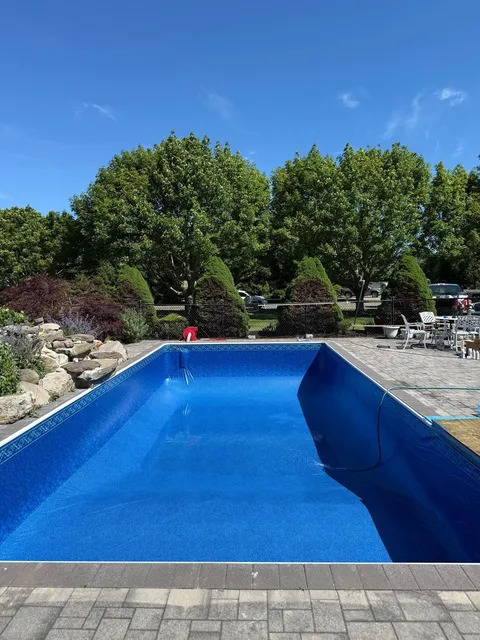 The same pool with a new blue liner, filling with water