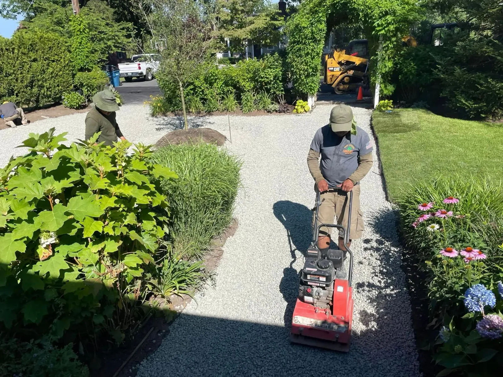 a man is using a machine to level a gravel driveway