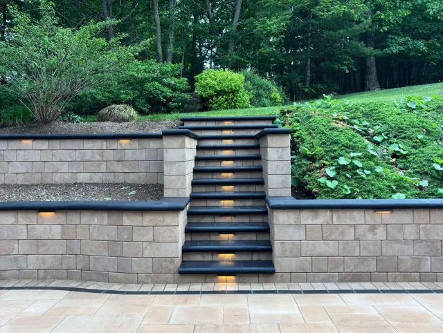 Stone steps leading up a landscaped garden terrace with greenery and retaining walls