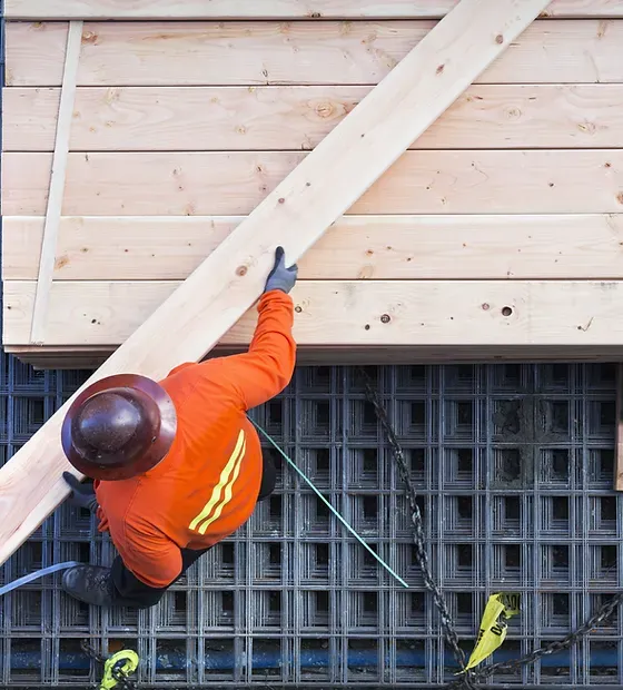 Construction Worker Lifting Wood Board