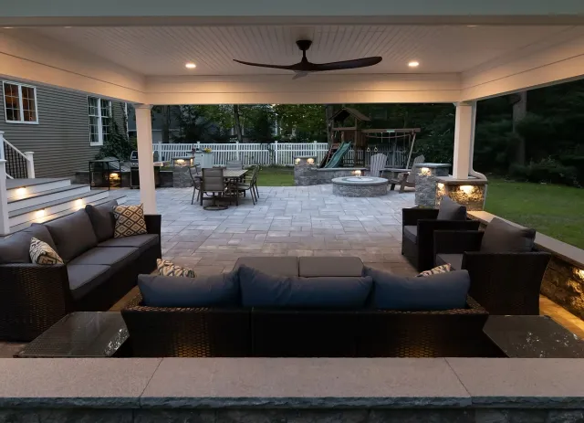 Cabana view of newly installed cabana, fire pit and seating wall on paver patio in Mansfield, MA, installed by JS Hardscapes.