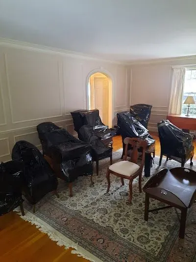 A living room filled with furniture wrapped in plastic.