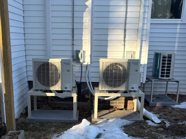 Three Daikin ductless heat pump outdoor units installed on raised stands in Portland, Maine