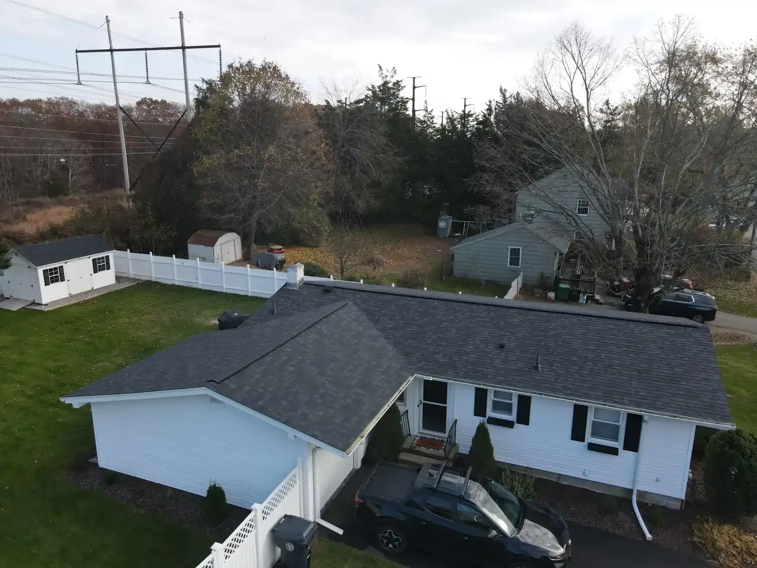 Aerial view of a completed asphalt shingle roof replacement by A&M Property Solutions on a Rhode Island home.