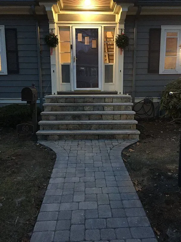A brick walkway leading to the front door of a house