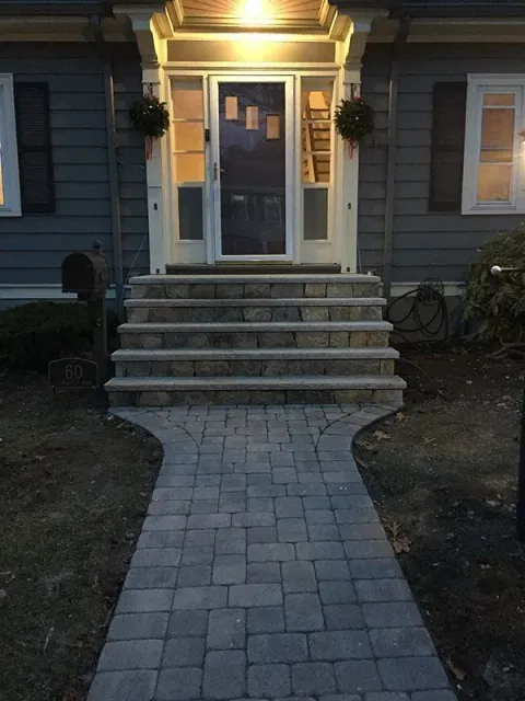 A brick walkway leading to the front door of a house