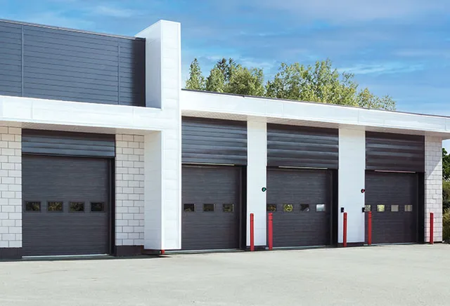 Black G-5000 garage doors on a white industrial building in Bridgeport, installed by Ridgefield Door Systems