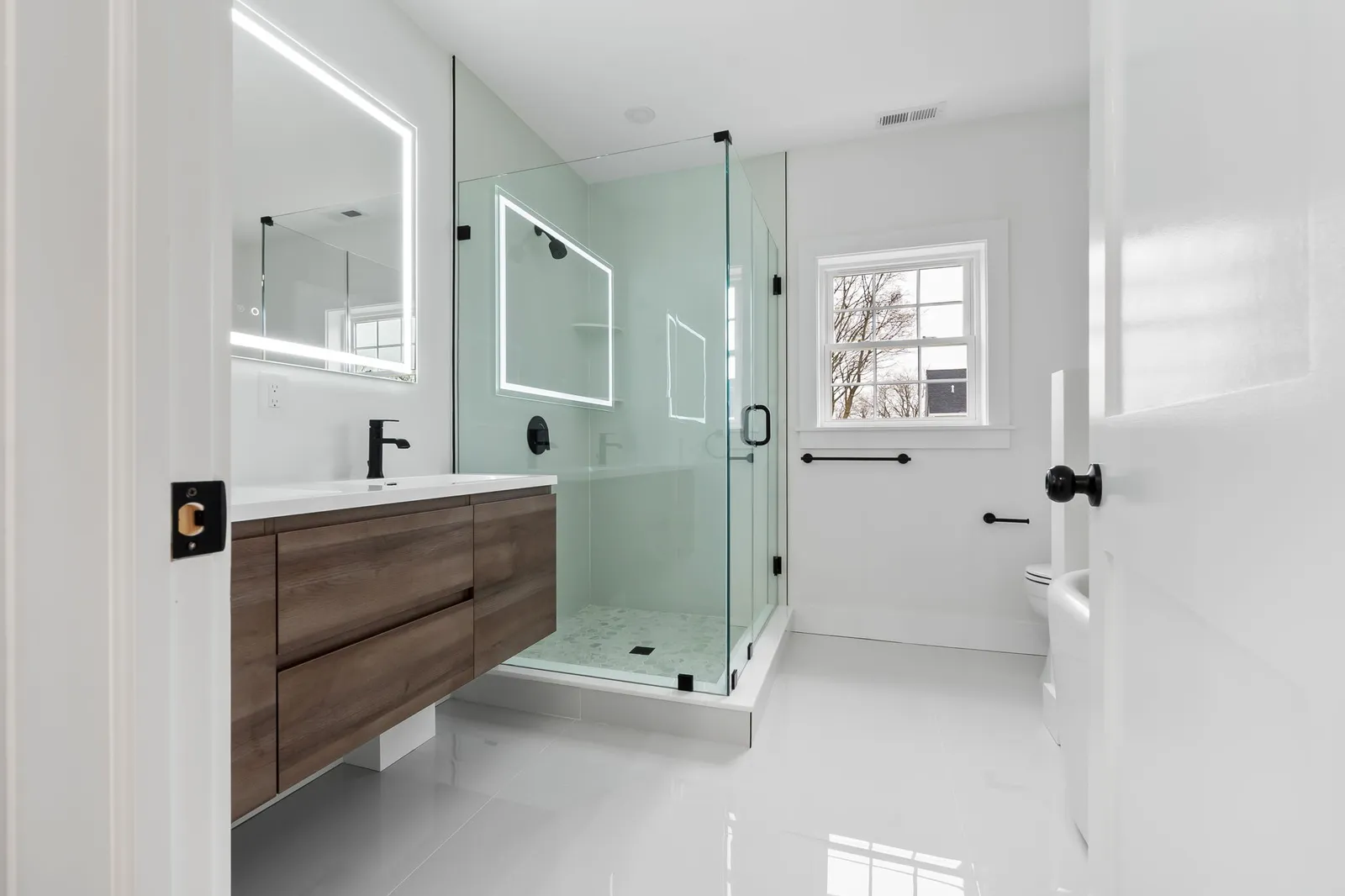 Renovated bathroom with floating vanity and glass shower
