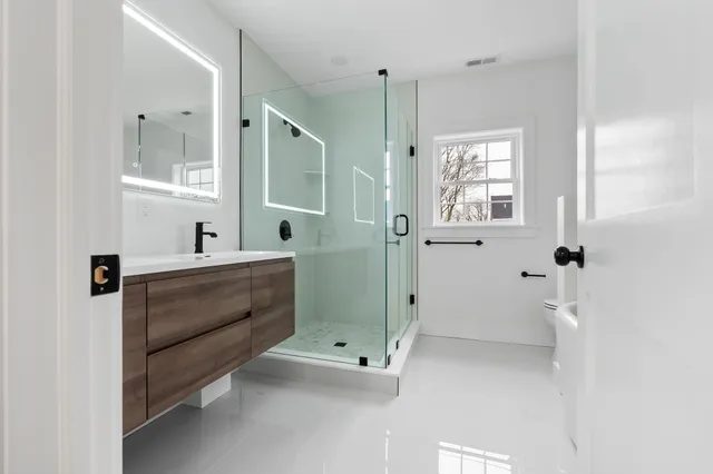 Renovated bathroom with floating vanity and glass shower