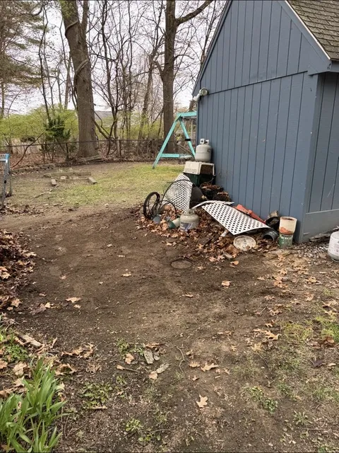 Side yard cleared, open ground beside the shed