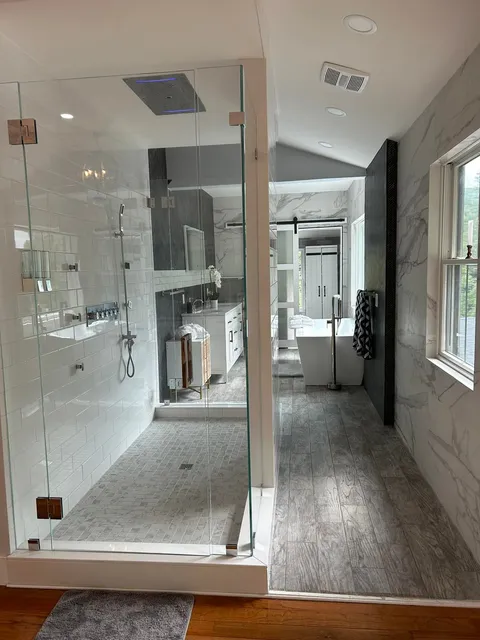 Modern bathroom renovation with tile shower and freestanding tub