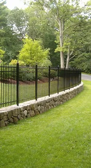 Black ornamental fence bordering a lawn